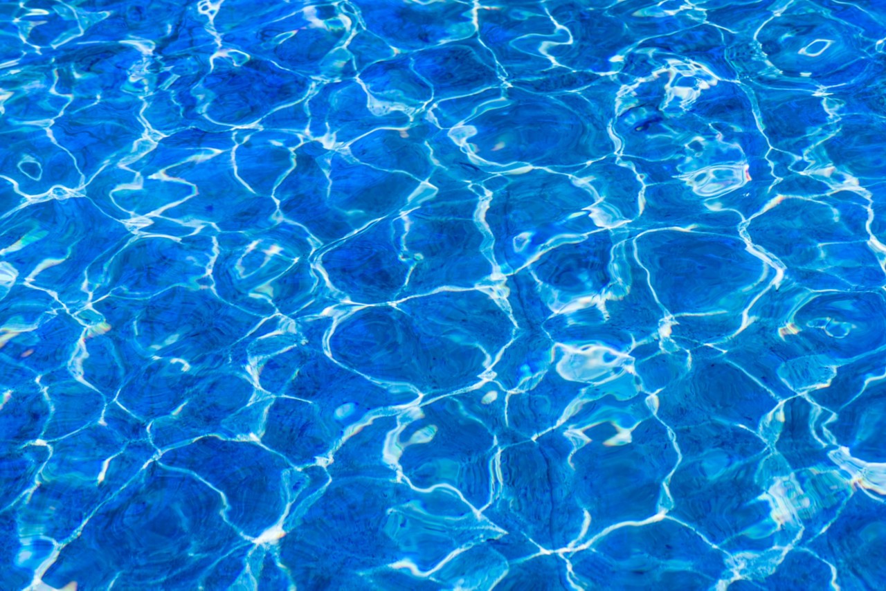 Clear and clean water. Closeup view of a fresh, clean, clear and cool water. Invitation to summer vacations. Blue and white colors, play of light, shade and reflections
